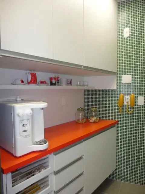Cozinha planejada com armário de cozinha de parede branca e bancada laranja Projeto de Maria Helena Torres