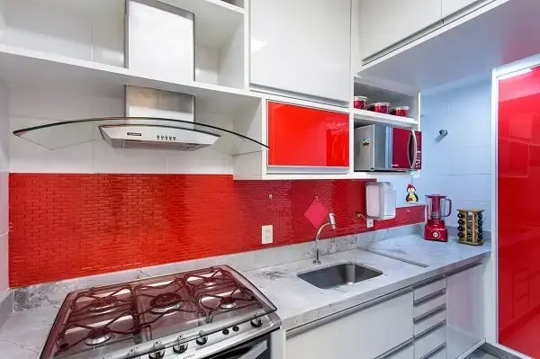 O fogão se encaixa na bancada da cozinha vermelha