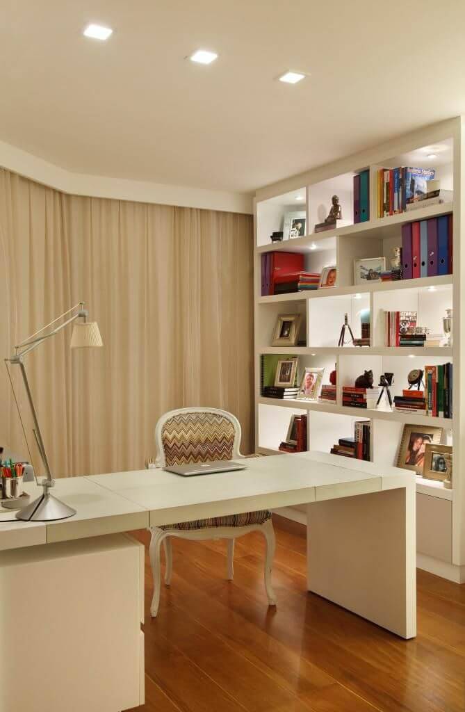 Home office com piso de madeira e móveis brancos Projeto de Vivian Coser