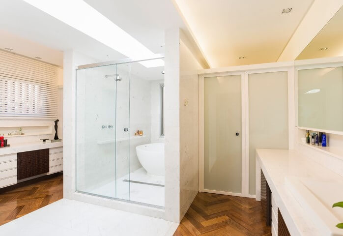 Sala de banho com piso de madeira e parte em outro tipo de piso Projeto de Leonardo Muller