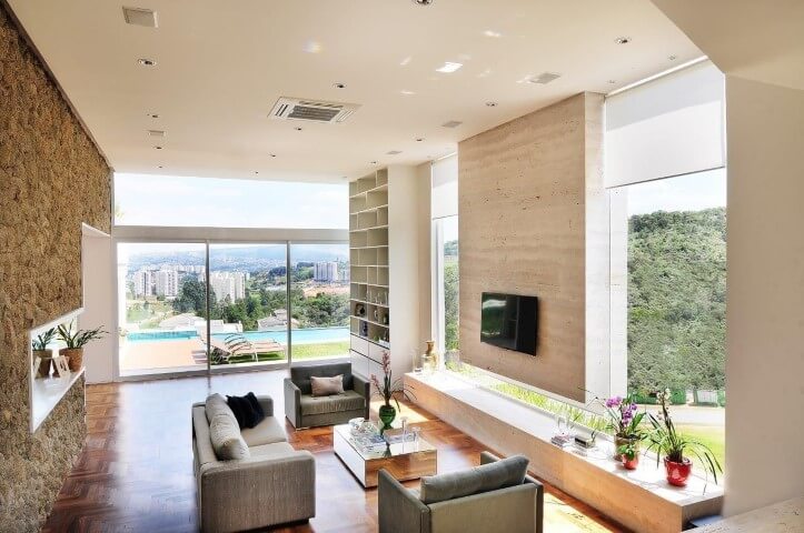 Sala de estar ampla com piso de madeira de taco Projeto de Quitete Faria