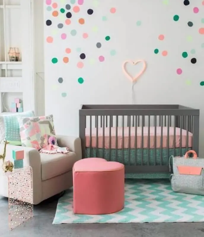 decoração com adesivos para quarto de bebê com puff em formato de coração e berço cinza Foto Revista VD
