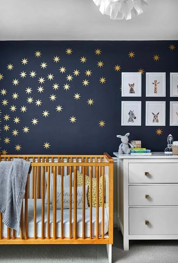 estrelas de adesivos para quarto de bebê com parede azul marinho e berço de madeira Foto Why Santa Claus