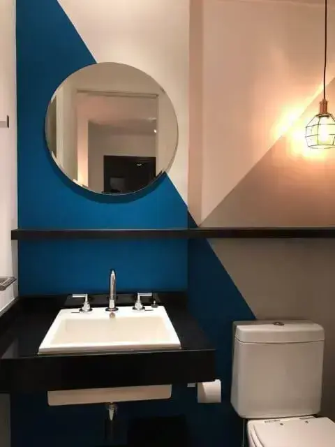 Banheiro com parede com três cores e espelho para banheiro redondo Projeto de Casa On