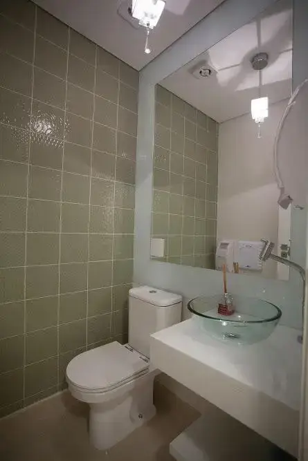 Banheiro de consultório com espelho para banheiro Projeto de Simone Schneider