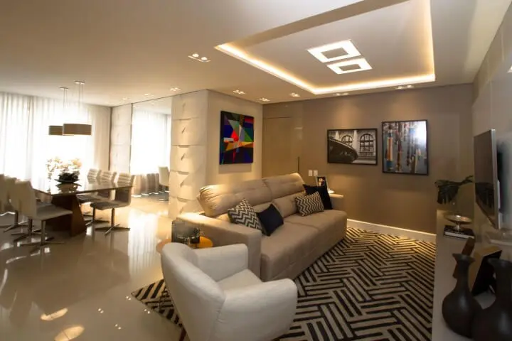 Sala de estar integrada com sala de jantar com sanca de gesso e luminárias embutidas Projeto de Marina Turnes