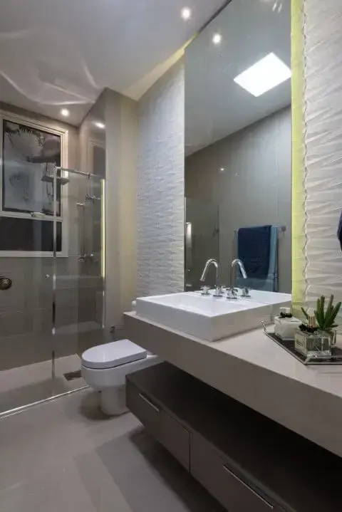 Banheiro com revestimento 3D e iluminação embutida atrás do espelho Projeto de Marie Lauzan