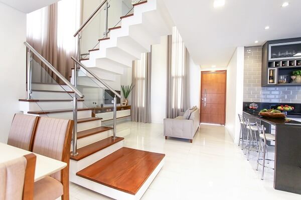 Escadas para casa com porta de madeira e revestimento branco