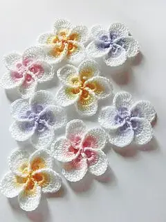 Flor de crochê brancas com centros coloridos