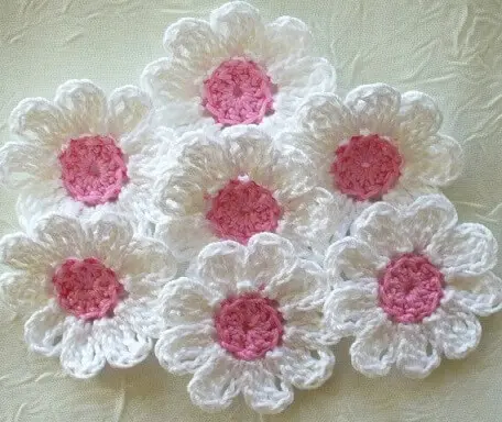 Flor de crochê brancas com centros rosas