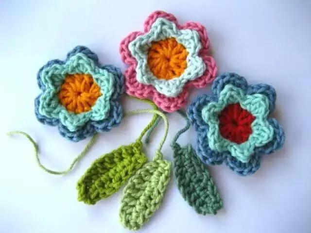 Flores de crochê coloridas com folhas