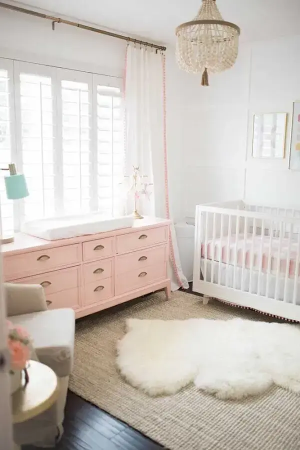 quarto de bebê decorado com cômoda rosa e tapete felpudo Foto The Posh Home