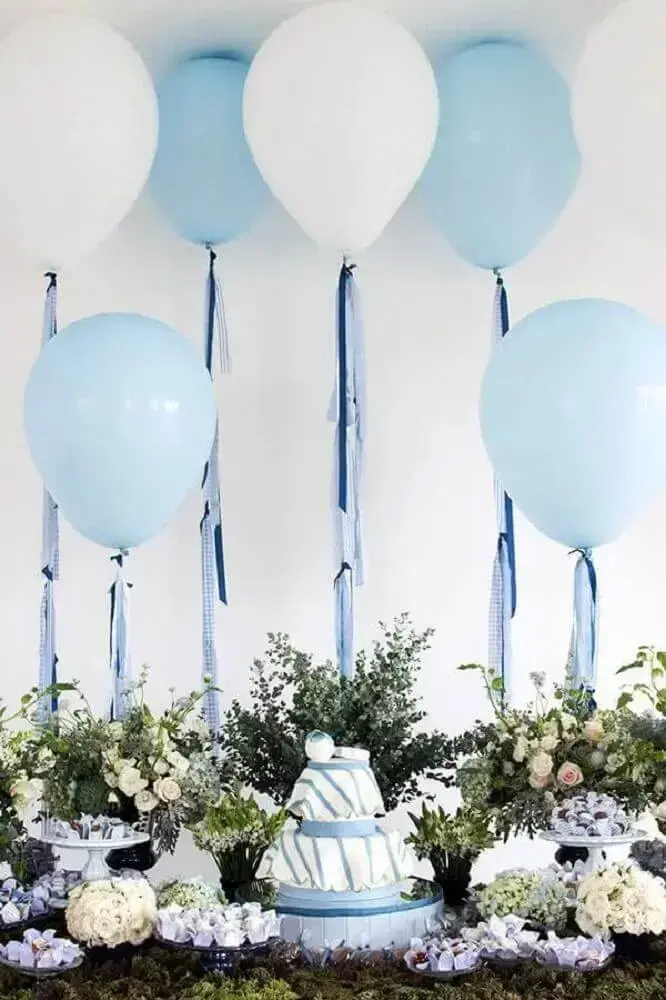 mesa de chá de bebê menino decorada com arranjos de flores e balões brancos e azuis Foto Pinterest
