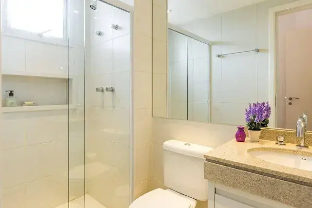 Decoração de banheiro clara com espelho grande gabinete e nicho Projeto de By Arquitetura