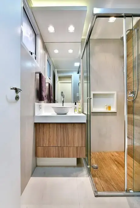 Decoração de banheiro com gabinete e chão do box de madeira Projeto Tetriz Arquitetura