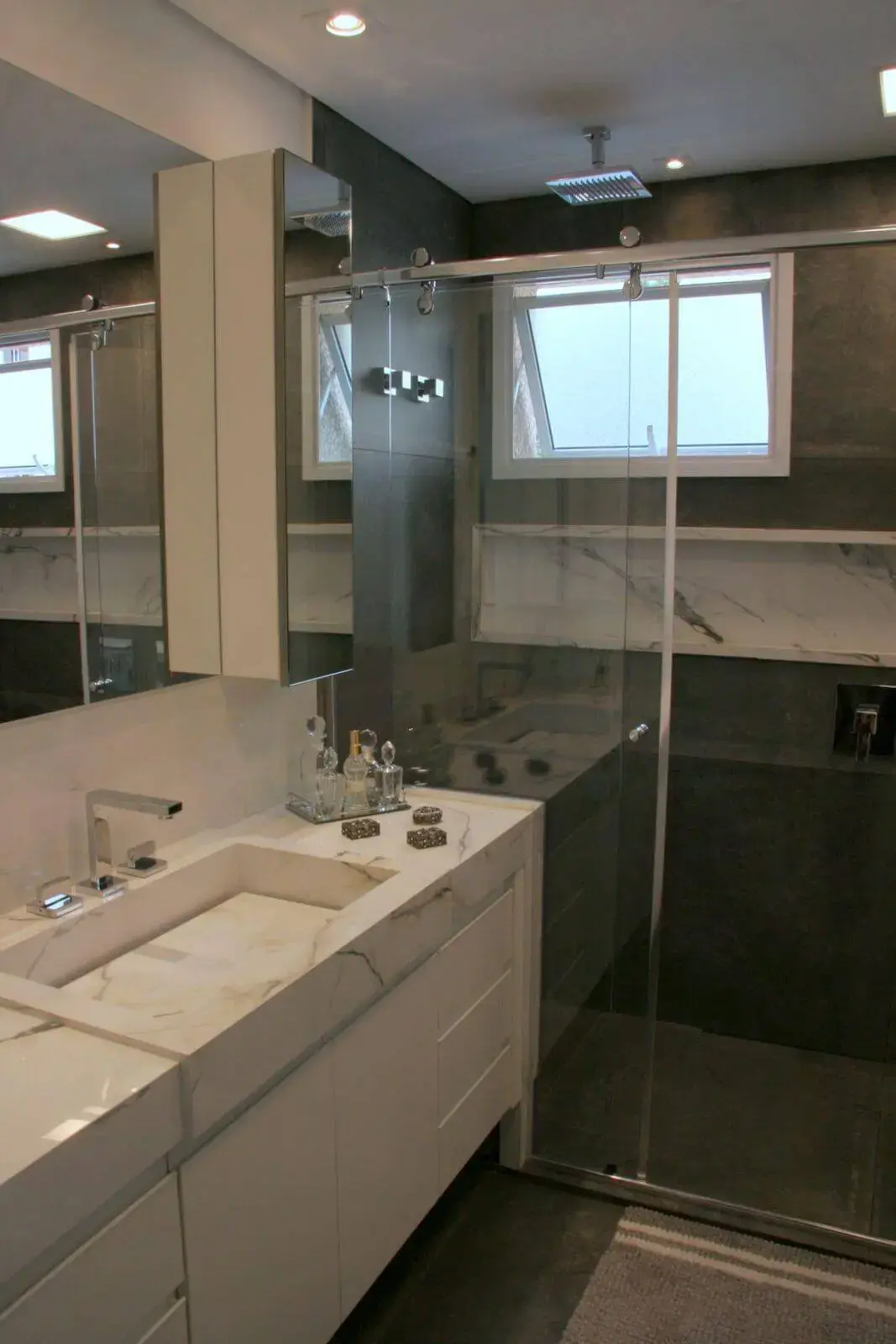 Decoração de banheiro com gabinete, espelho amplo e nicho Projeto de Moussi Arq