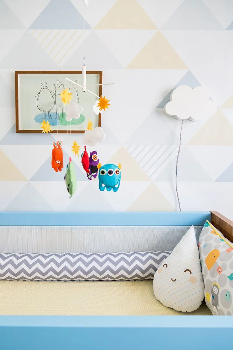 Decoração de quarto de bebê com cores suaves e detalhes mais fortes no móbile Projeto de Studio Novak