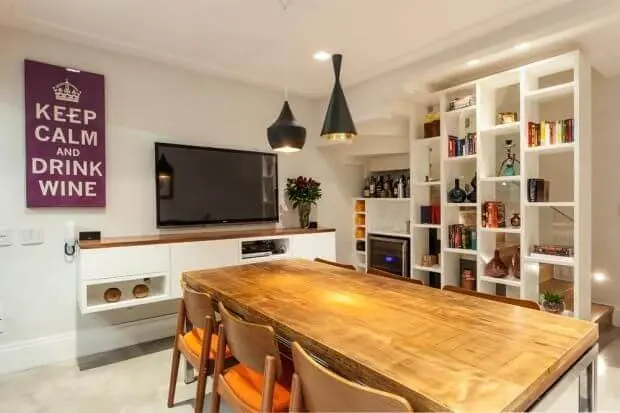 Sala de jantar com TV e estante com objetos de decoração Projeto de Arq In Arquitetura