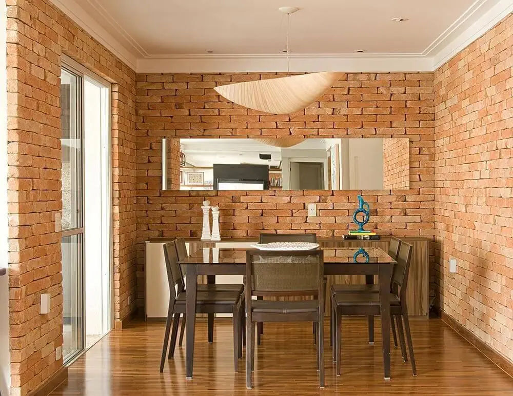 Sala de jantar com buffet e paredes de tijolos aparentes Projeto de Díptico Design de Interiores