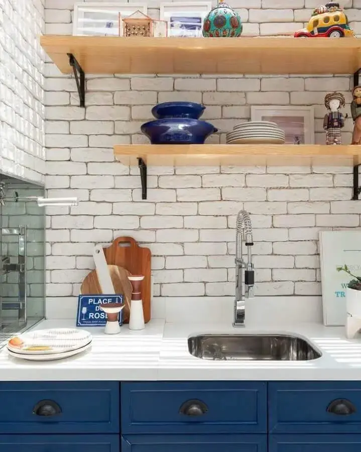 decoração com prateleira para cozinha com armários azuis e parede de tijolinho branco Foto Duda Senna Arquitetura