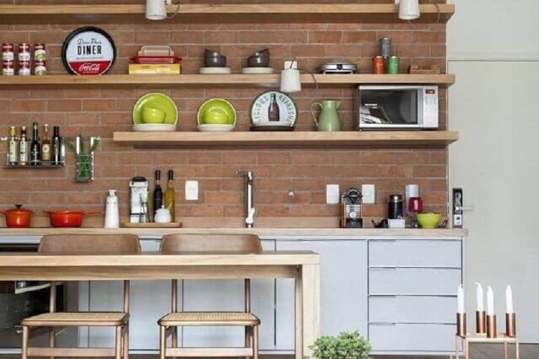 prateleira de madeira para cozinha decorada com parede de tijolinho Foto Migs Arquitetura