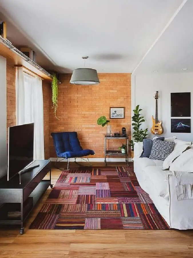 tapete colorido para sala com sofá branco e parede de tijolinho Foto A Casa Delas