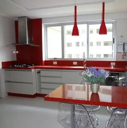 Cozinha modulada com armário branco e decoração vermelha