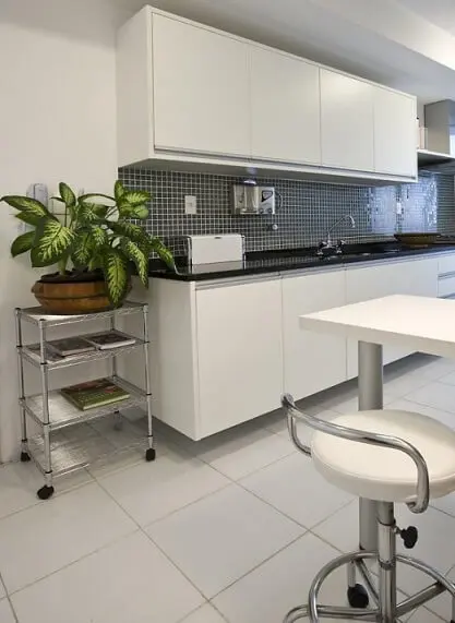 Cozinha modulada com móveis brancos e rodabanca escura