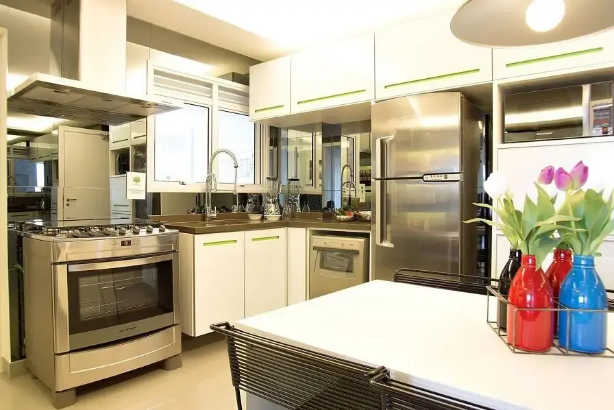 Cozinha planejada com armários brancos com puxador verde Projeto de Basiches