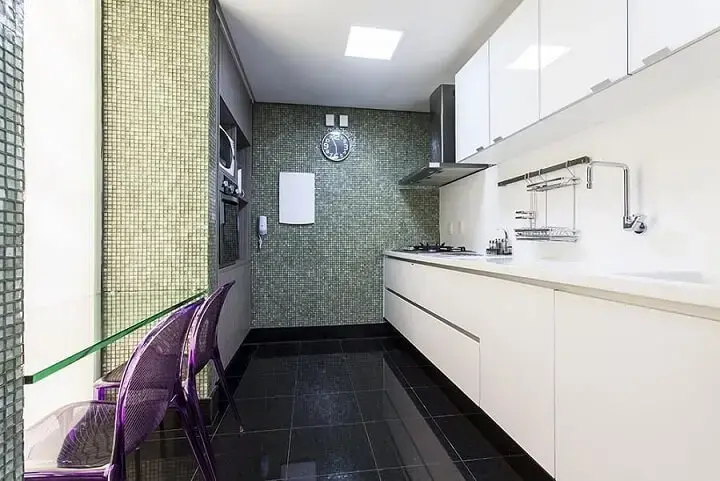 Cozinha planejada com armários brancos e bancada de vidro encaixada Projeto de Gabriele Luiz