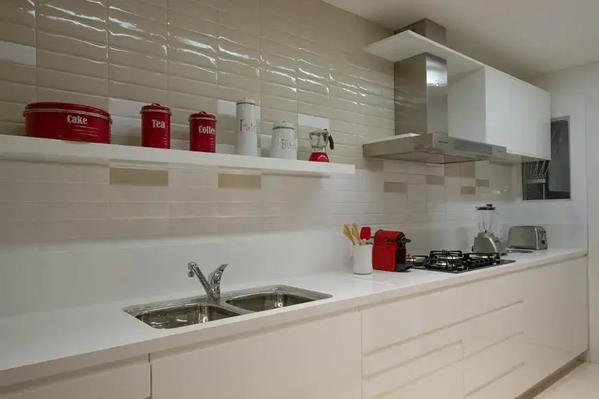 Cozinha planejada com armários brancos e pia dupla Projeto de Cristina Rei