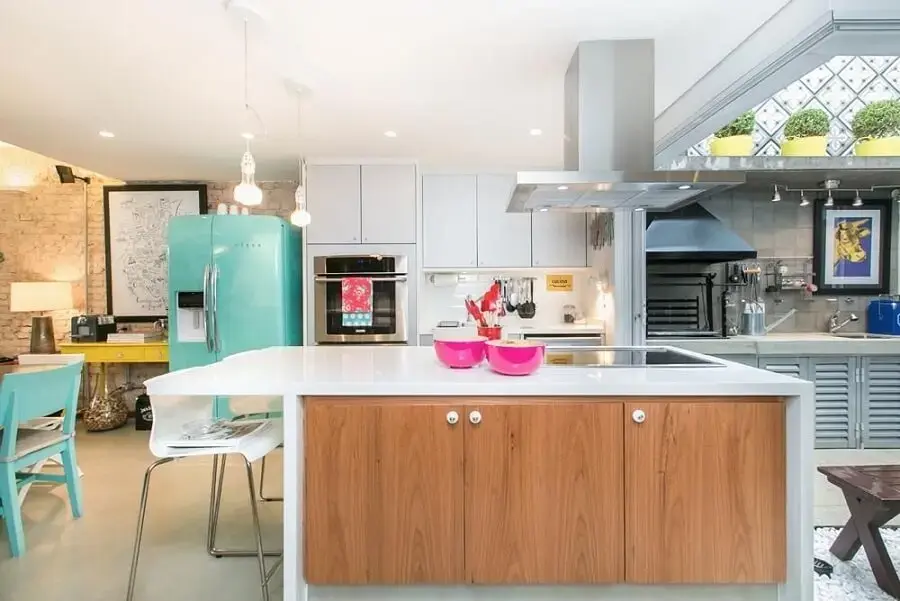 Cozinha planejada com bancada central e decoração colorida Projeto de DT Estudio