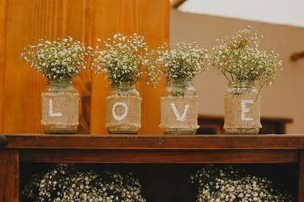 Decoração de casamento com potes de vidros, juta e flores brancas