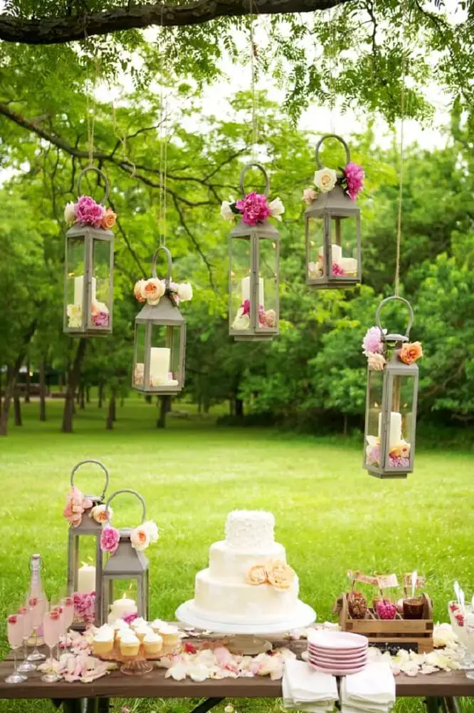 Decoração de casamento ao ar livre com velas e flores suspensas