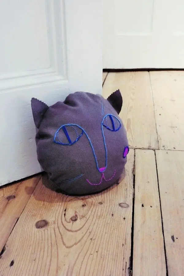 Peso de porta com traços delicados forma a imagem de um gatinho. Fonte: Super Super Hq