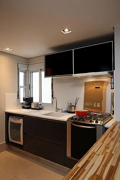 Pia de cozinha de mármore branco em contraste com os armários pretos Projeto de Karen Pisacane