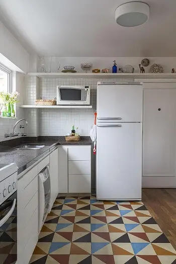 Pia de cozinha dupla de mármore escuro em cozinha com armários, prateleiras e eletrodomésticos brancos Ptojeto de Leila Dionizio