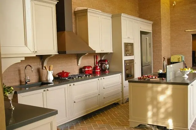 Pia de cozinha em pedra preta em cozinha com bancadas pretas e armários claros Projeto de Adriana Giacometti