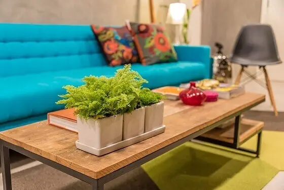 Sala-de-estar-com-mesa-de-tampo-de-madeira-e-sofá-azul-turquesa-Projeto-de-Viviane-de-Pinho