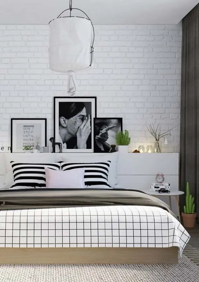 decoração de quarto tumblr branco e preto com parede de tijolinho e quadros apoiados em prateleira Foto Só Decor
