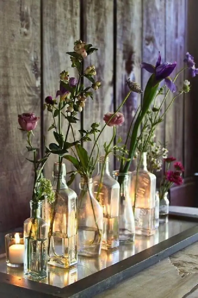 decoração feita com garrafas de vidros como vasos de flores