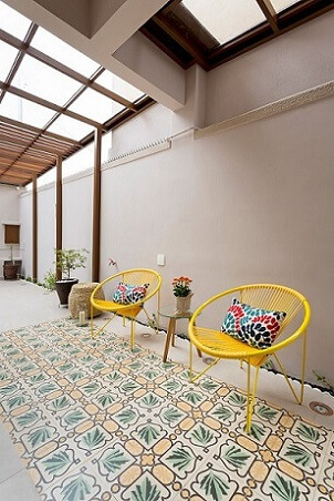 Almofadas decorativas coloridas em cadeiras amarelas Projeto de Juliana Conforto