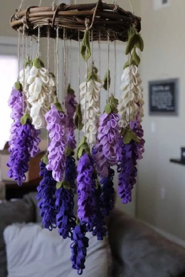 Arranjos de flores artificiais pendentes feitas em tecido decoram o espaço