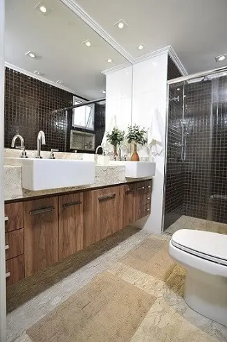 Banheiro do casal com bancada e rodabanca de mármore travertino Projeto de Ana Cristina Nigro Malta