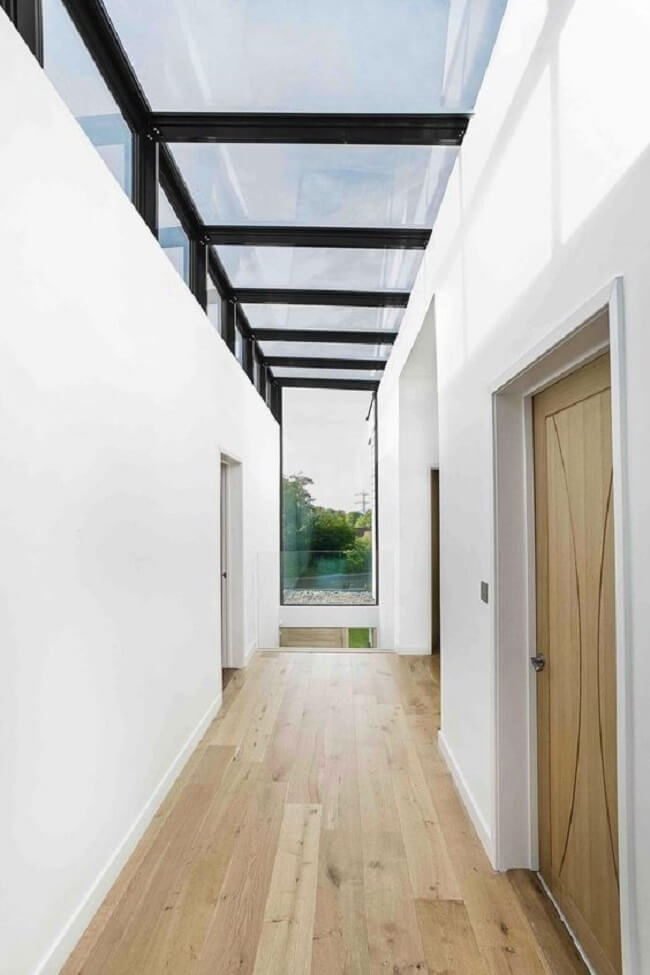 Casa moderna com piso de madeira e telhado de vidro