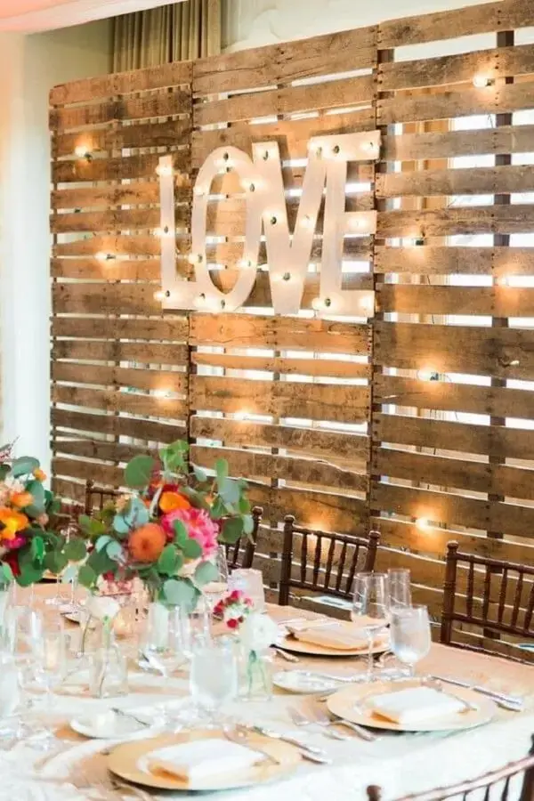 Pallet panel and lights are part of simple wedding decoration