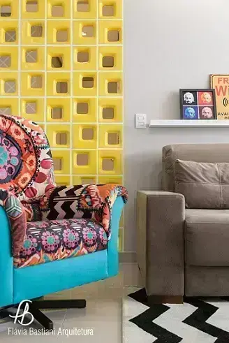 Sala de estar colorida com cobogó amarelo separando do corredor Projeto de Flavia Bastiani