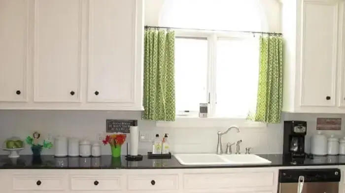 Varão de metal e cortina verde decora a cozinha simples