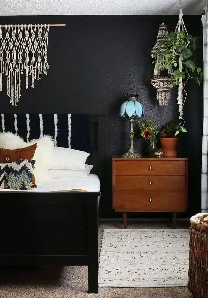 quarto com parede preta decorado com móveis de madeira