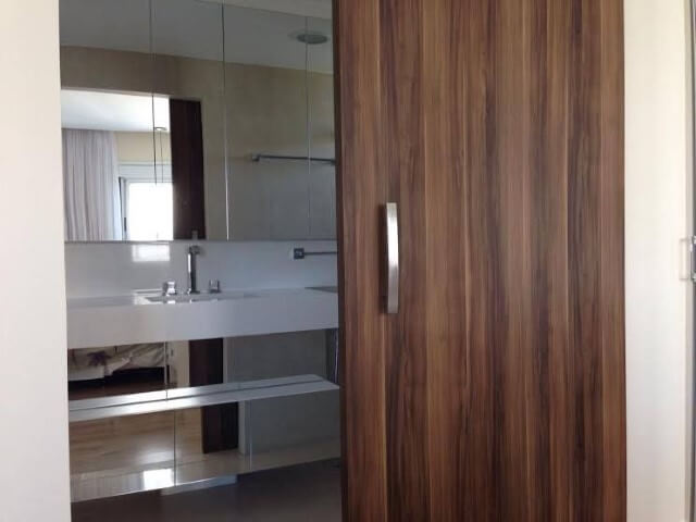 Banheiro com porta de correr com roldana aparente Projeto de Studio Infinite Arquitetura